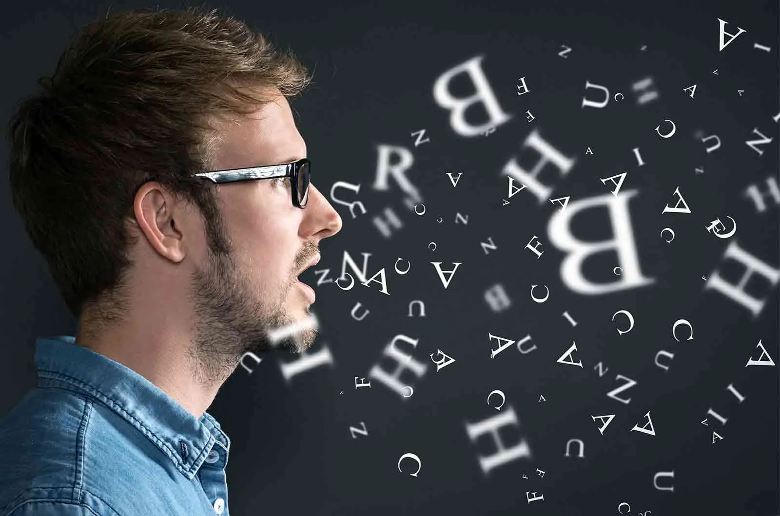 Young man wearing glasses and talking with English letters coming out of his mouth. Concept of language translation agency.