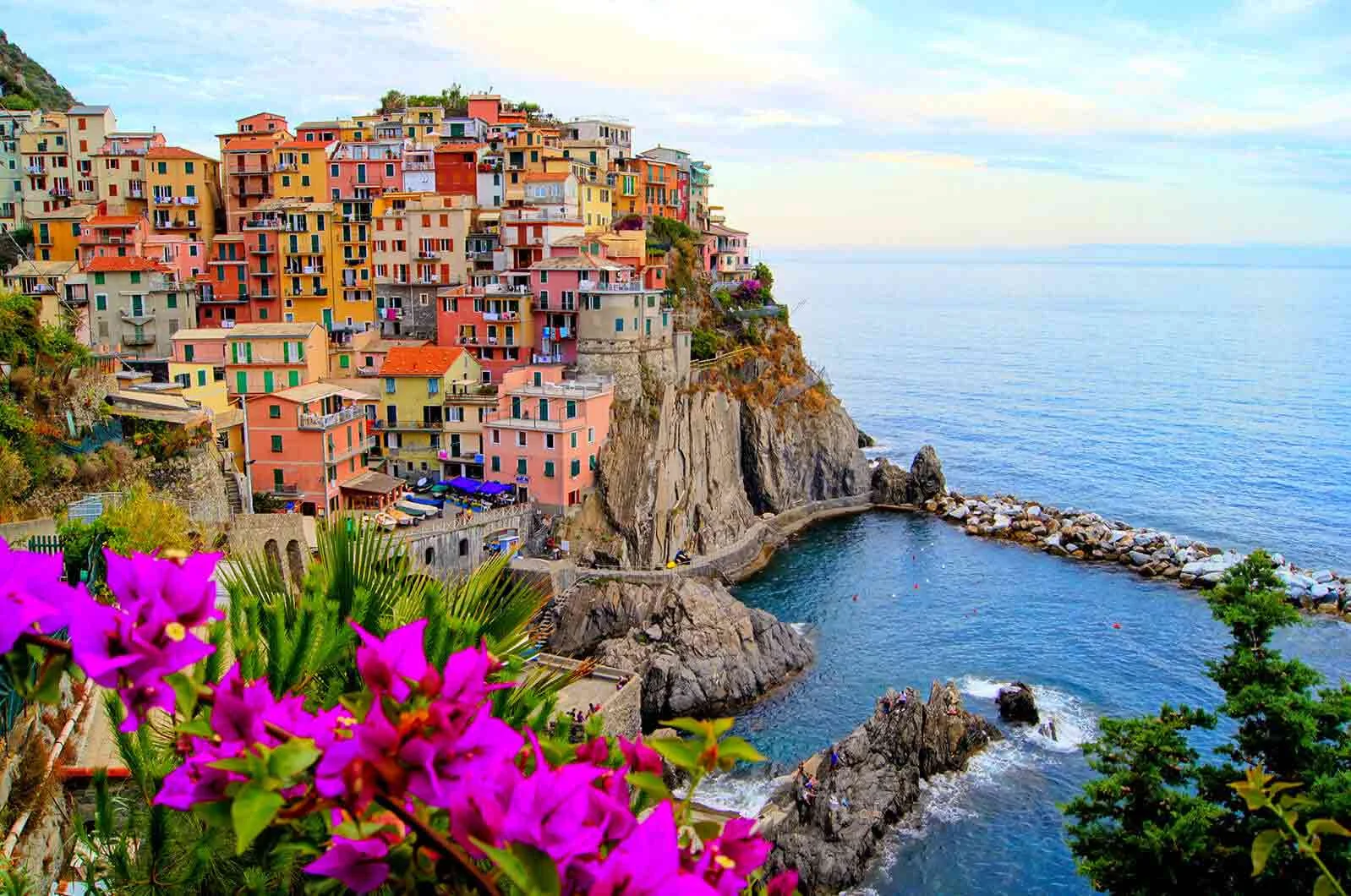 Beautiful picture of Italian village, Manarola, with the coast of Cinque Terre and flowers. Concept of European, Latin and Romance languages.