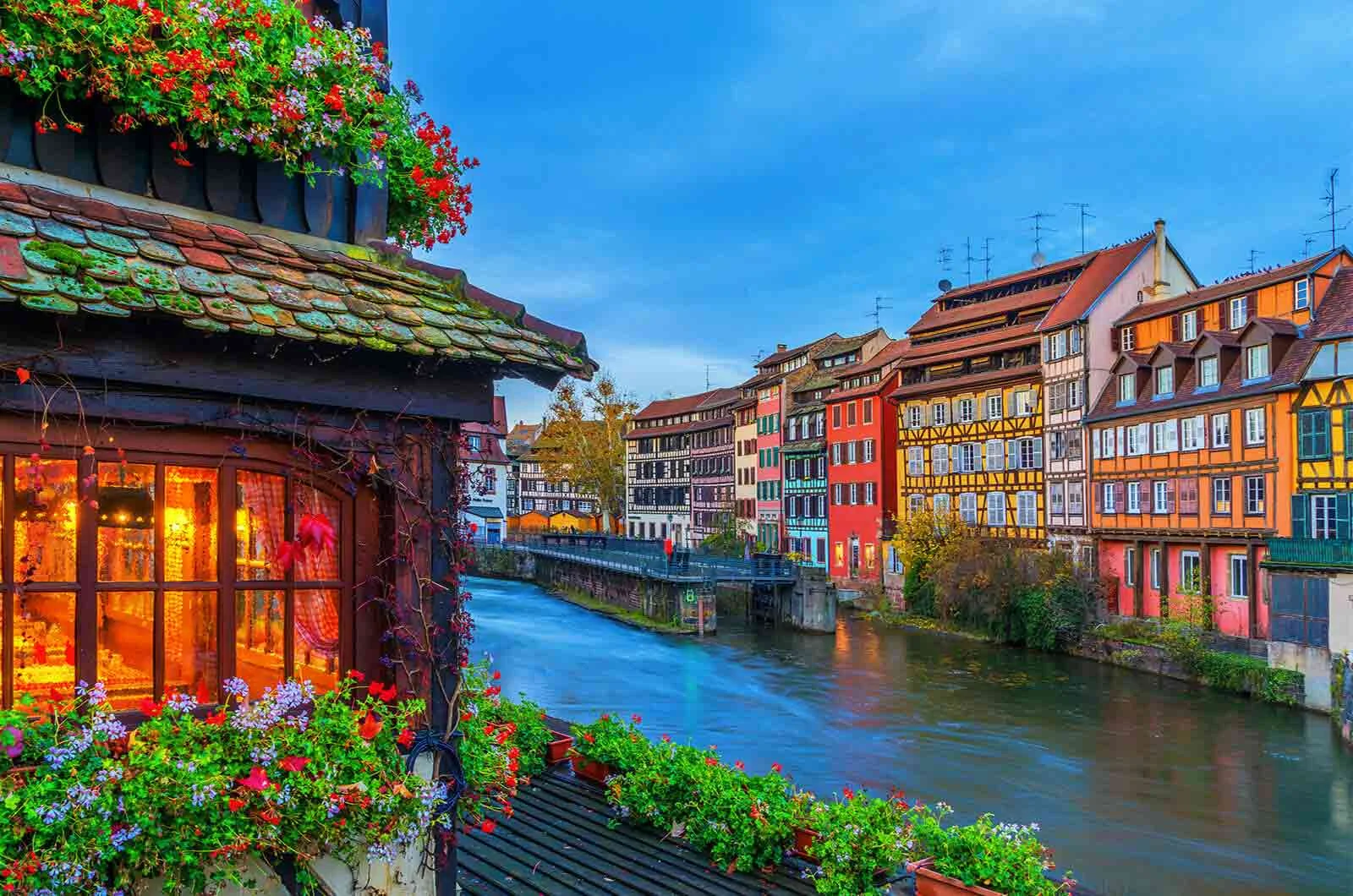 Colourful buildings on the bank of a river in Strasbourg, Alsace, France. Concept of the French language.
