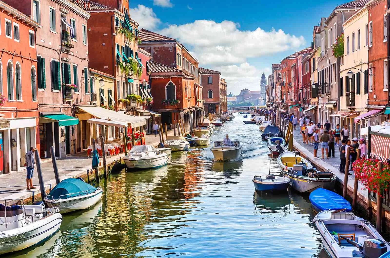 A canal in Venice, Italy with boats and buildings on its edge. Concept of Italian translations.