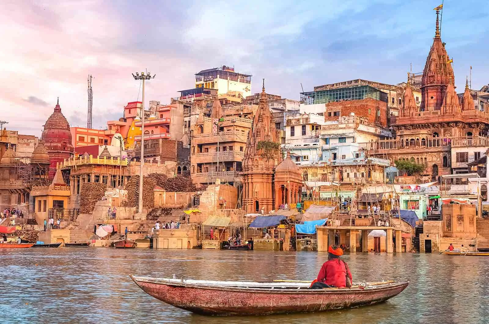 An Indian man on a boat in a river in Varanasi City, India. Concept of English to Hindi translation.