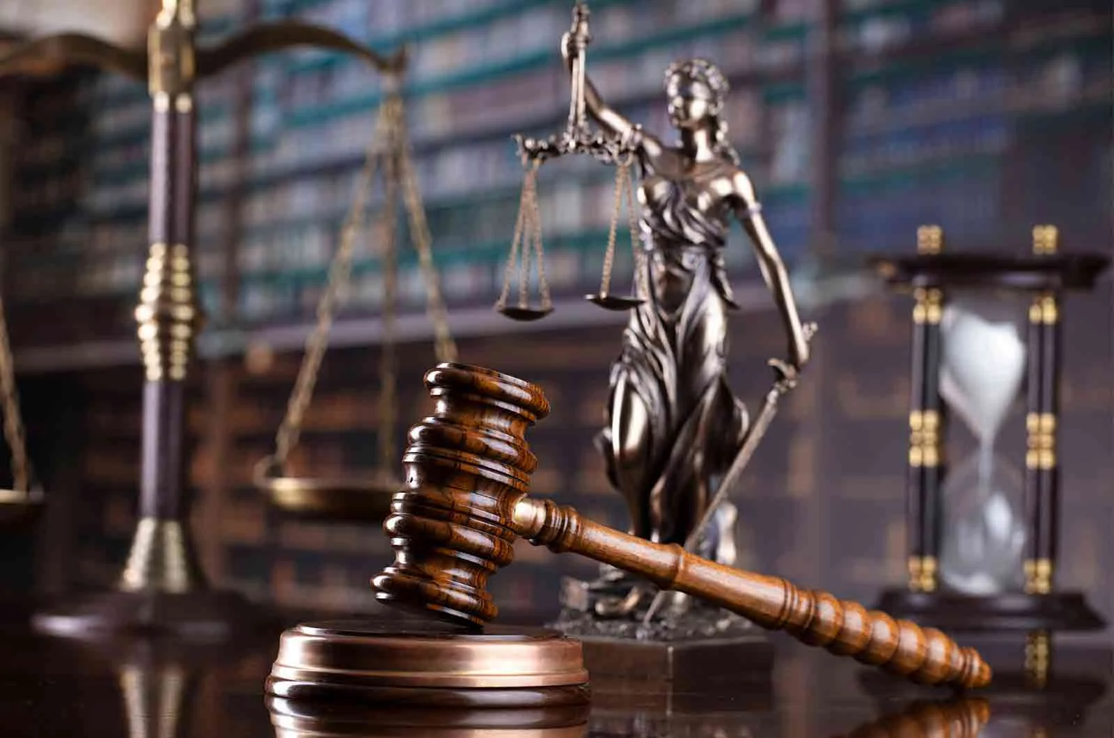 A judge's gavel on a desk in a library, next to a scale of justice. Concept of legal translations.