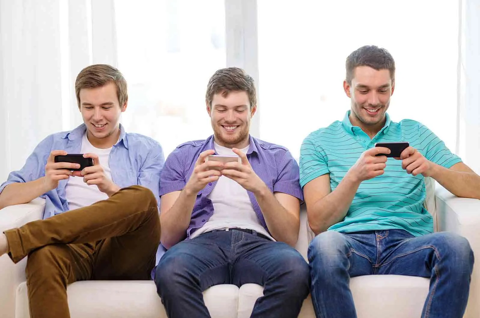 Three happy men playing video games with phones and wearing summer clothes. Concept of language translation and games localisation.