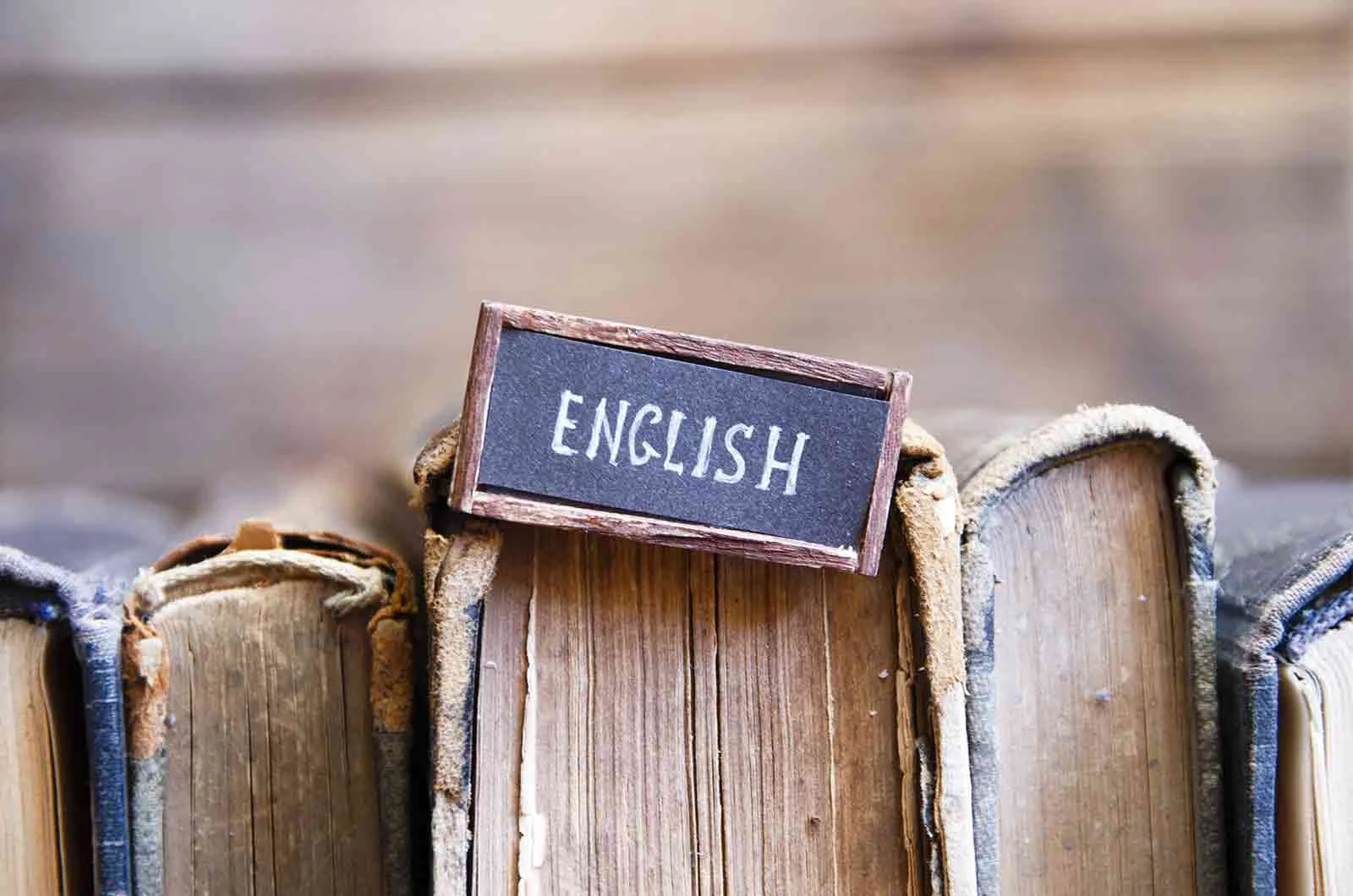 The word English on a cardboard sign attached to a book. Concept of the English language.