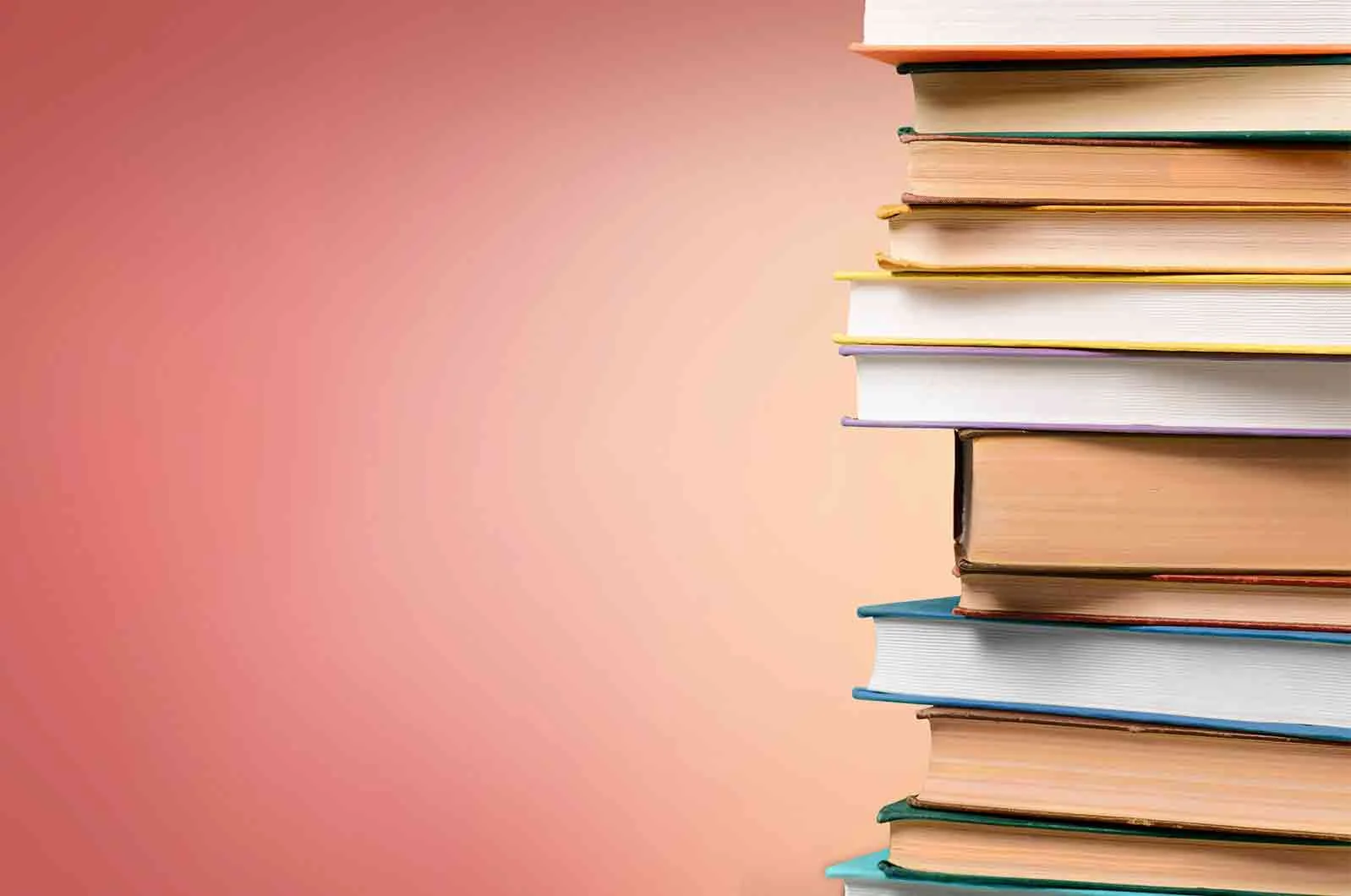 A group of coloured books and a library of books behind it. Concept of book translations.