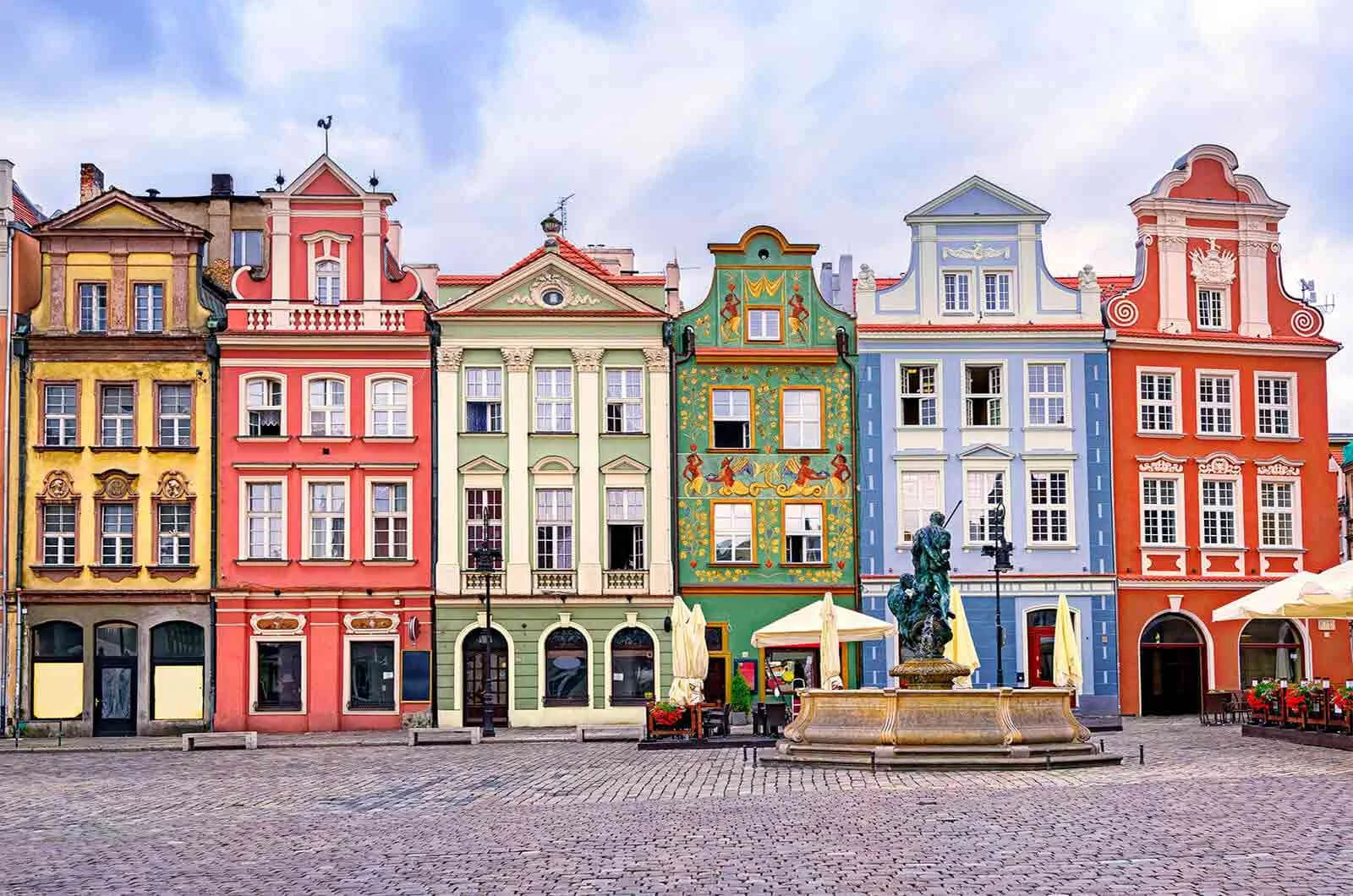Renaissance coloured facades in a central square and a fountain in Poland. Concept of English into Polish translation.