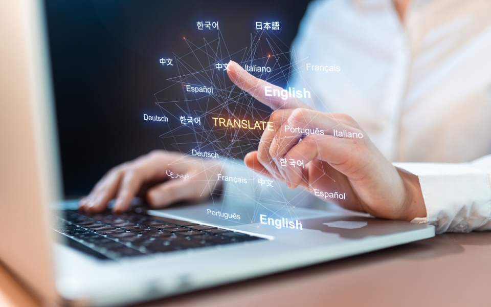 A person using a laptop with global language selection interface. Language translation technology, globalization, real-time translation and CAT tools for professional translators.