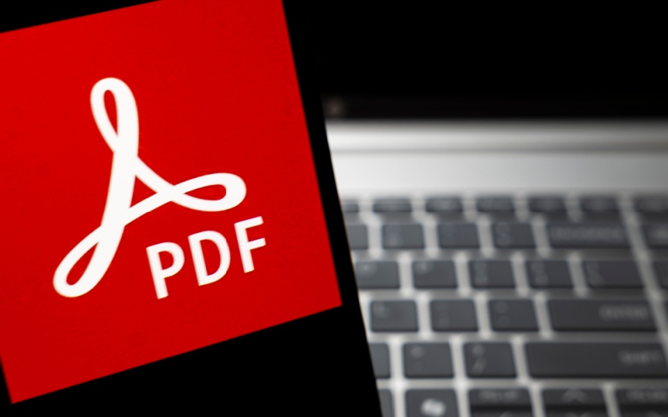 Close-up of the Adobe PDF logo on a smartphone screen, emphasizing PDF document translation to English and other languages and how it may be translated in modern platforms.