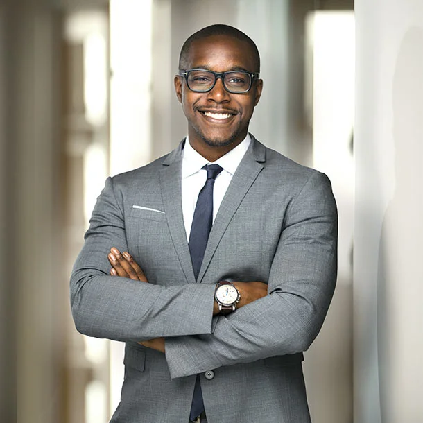 Professional African man standing in office with folded hands