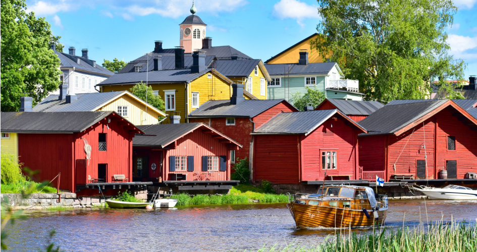 View of street, river and red wooden houses in Porvoo Old Town. Concept of Finnish translation services.