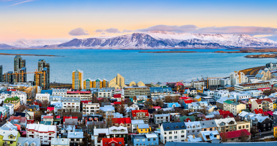 Panoramic view of Reykjavik city with colourful houses and snowy mountains. Concept of Icelandic translation services.