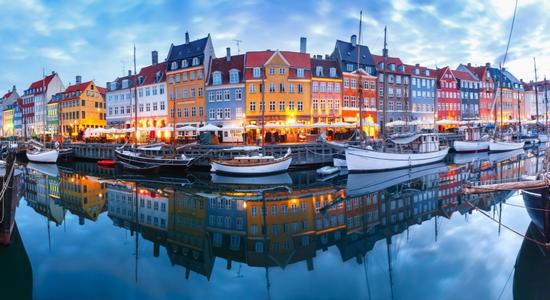 Nyhavn, a 17th-century waterfront, canal and entertainment district in Copenhagen, Denmark. Concept of Danish translation by professional Danish translators.