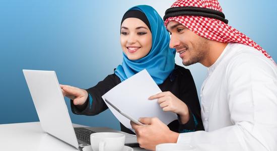 Arab man and woman working on laptop and holding paper in hands. Concept of Arabic translators