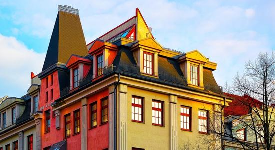 A colourful building with rectangular windows facing the sunset.