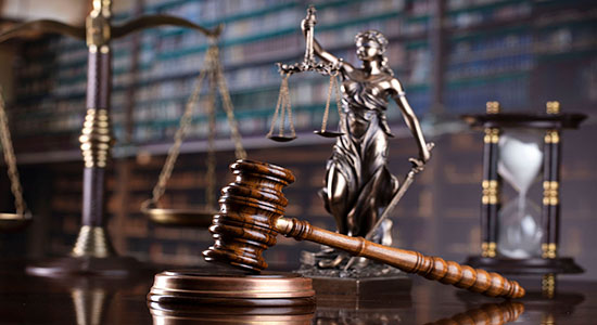 A judge's gavel on a desk in a library, next to a scale of justice. Concept of legal Czech translation.