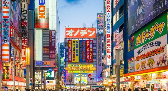 A busy street with a large crowd and many Japanese store signs.