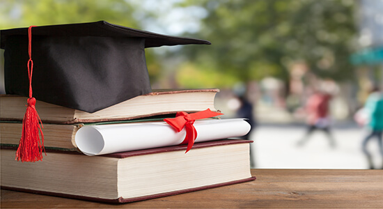 Books, certificate and cap on table. 