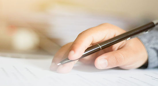 Man using pen to sign on paper contract. Concept of legal Kazakh translation.