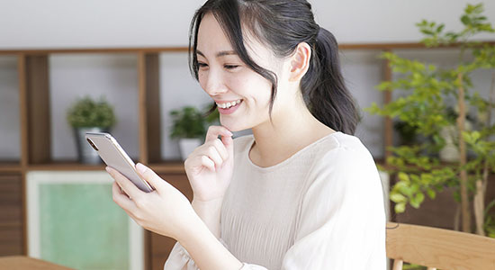 Asian woman using smartphone while smarting. 