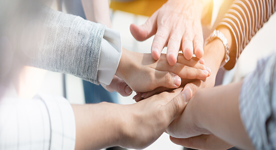 A group of volunteers stacking their hands on each other. 