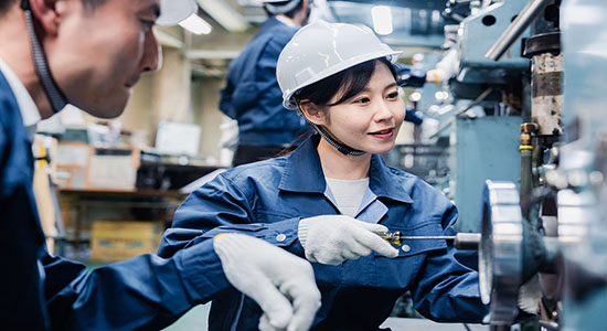 Man and young woman working in a factory. Concept of technical Kazakh translation.