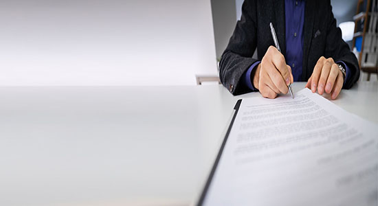 A professional lawyer signing on contract. Concept of legal Kurdish translation.