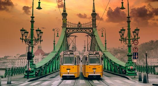 View of liberty bridge in Budapest with two old yellow trams. Concept of Hungarian translation services.