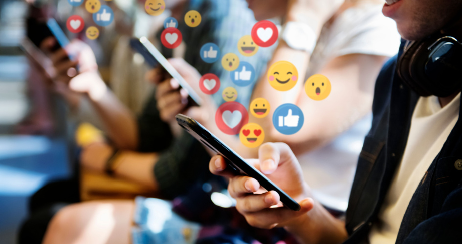 People using their mobiles with social emojis appearing. Concept of multilingual social media translation such as translation on Facebook.