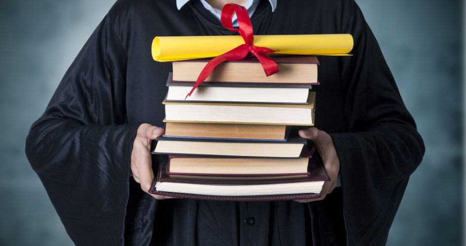 A male graduate holding several books with diploma. Concept of curriculum translation by professional curriculum translators.