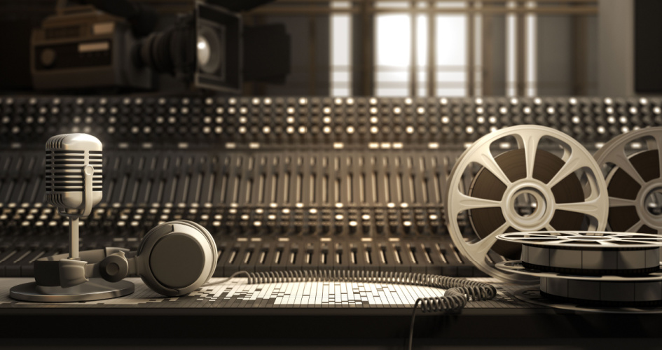 Reel with tape and equipment including microphone and headphones in a little light studio. Concept of transcription services. 
