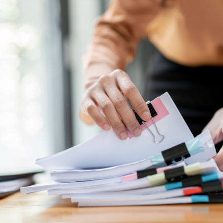 Man looking for a document in a stack of files.