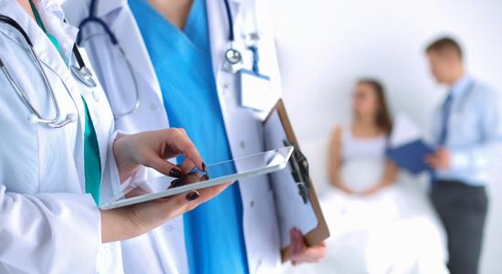 A female doctor holding tablet discussing results with another doctor. Concept of healthcare translation services. 