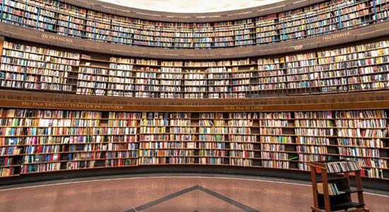 Interior of Stockholm Public Library, three stories of full bookshelves. Concept of academic translation services.