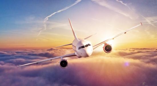 An aeroplane flying towards camera above clouds at sunset. Concept of air travel translation.