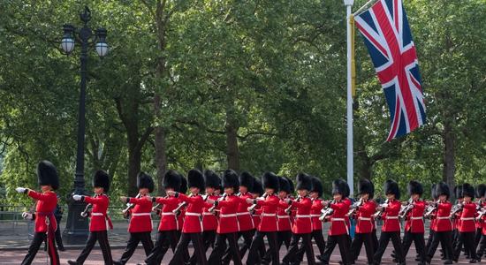 The King's Guard marching in their red and black uniforms. Concept of defence translation and military translation..