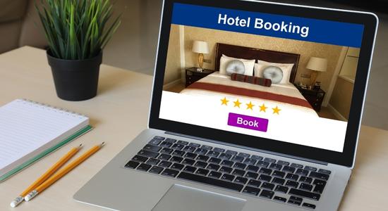 Person typing on a laptop showing hotel bookings for a premium apartment. 